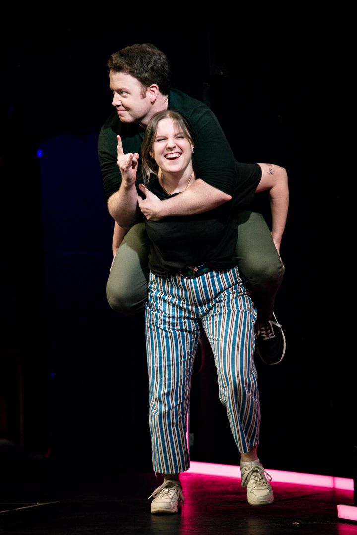 Izzy Roland gives Brennan Lee Mulligan a piggyback ride while Brennan makes devil horns in Bigger