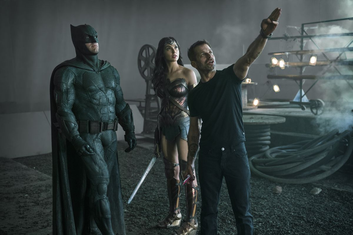 Batman, Wonder Woman, and Zack Snyder standing on the set of Justice League