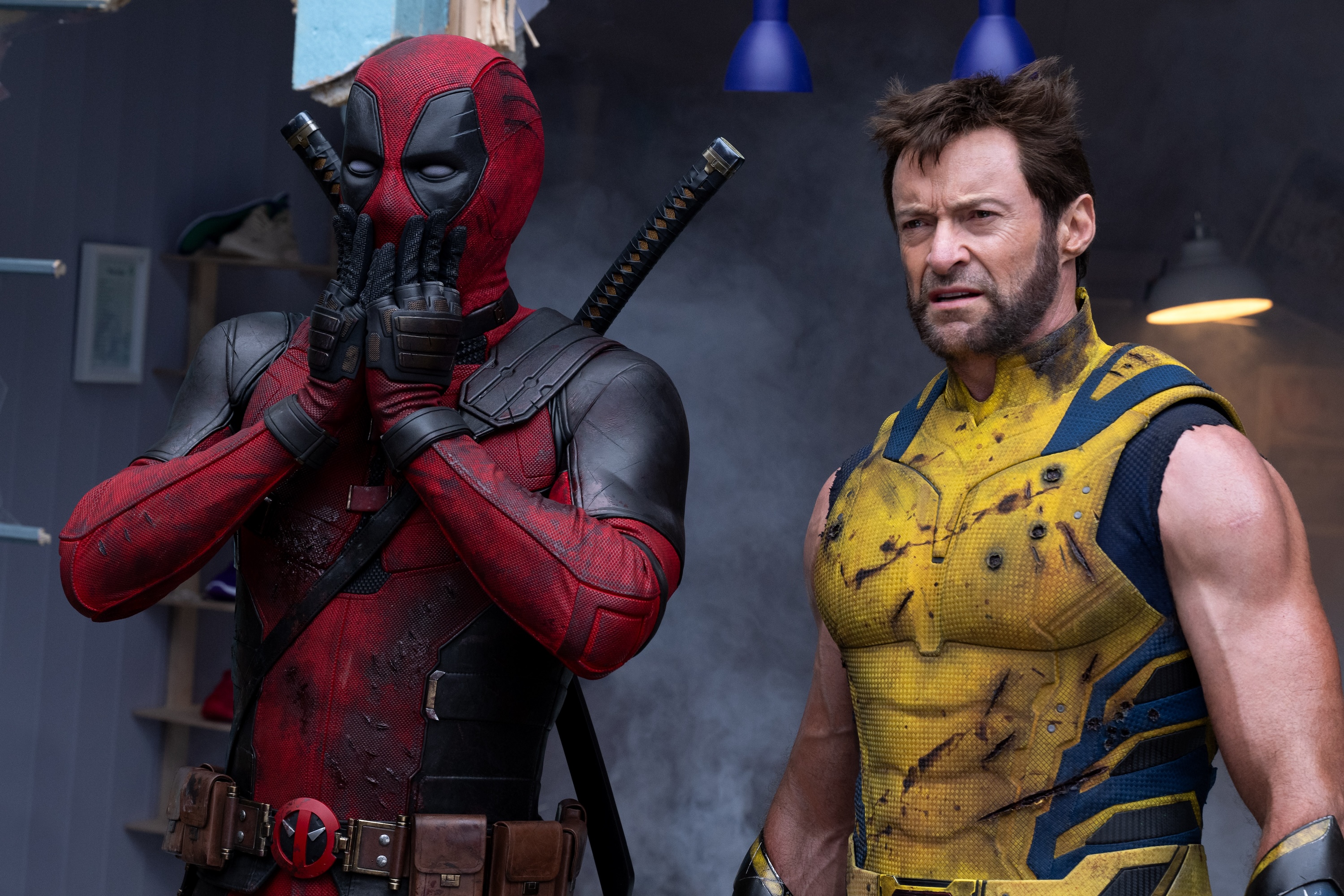 Ryan Reynolds as Deadpool/Wade Wilson and Hugh Jackman as Wolverine/Logan Deadpool and Wolverine. Deadpool has his hands pressed over his mouth humorously, while Wolverine looks tired.