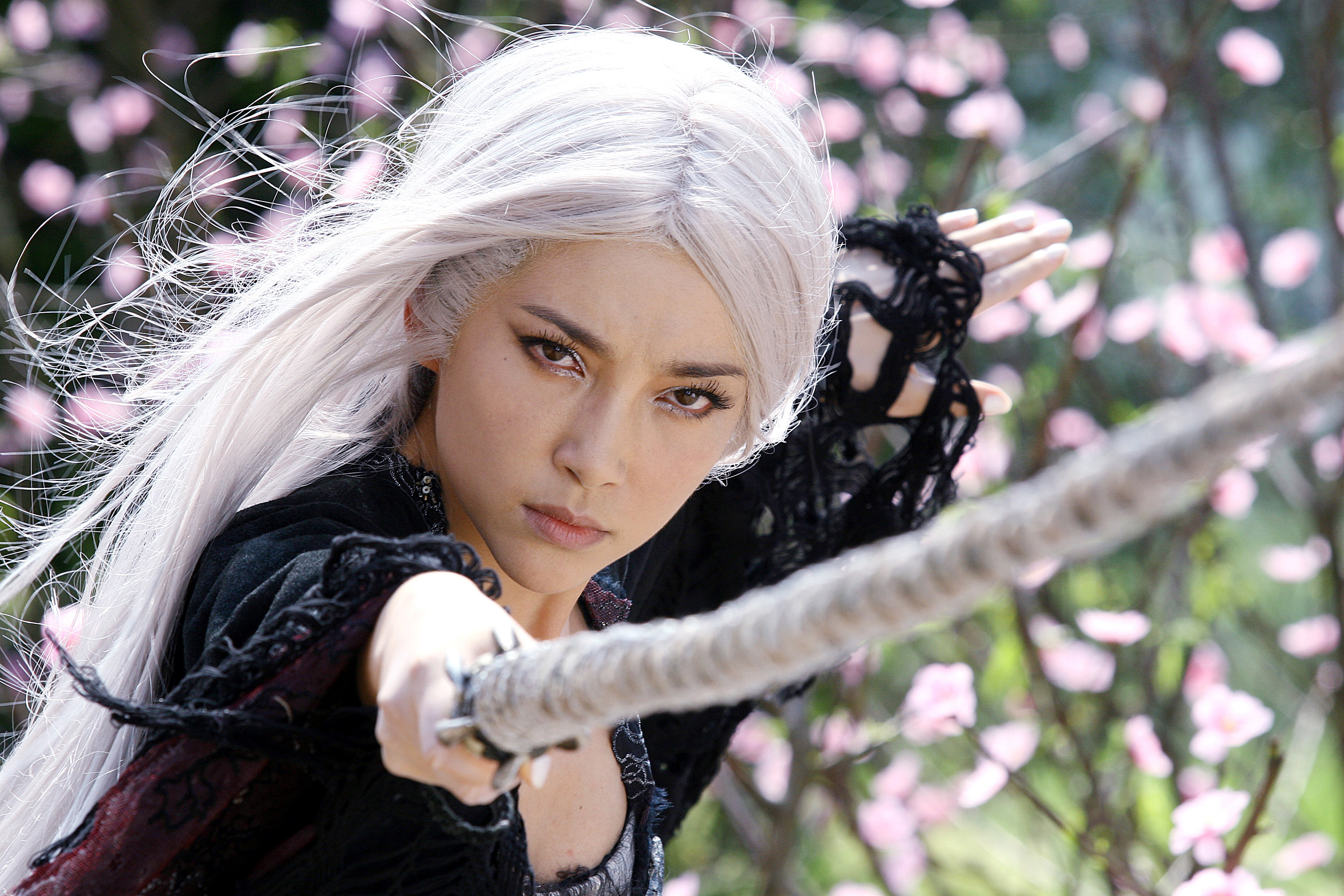 A woman with white hair holds a weapon toward the screen in The Forbidden Kingdom