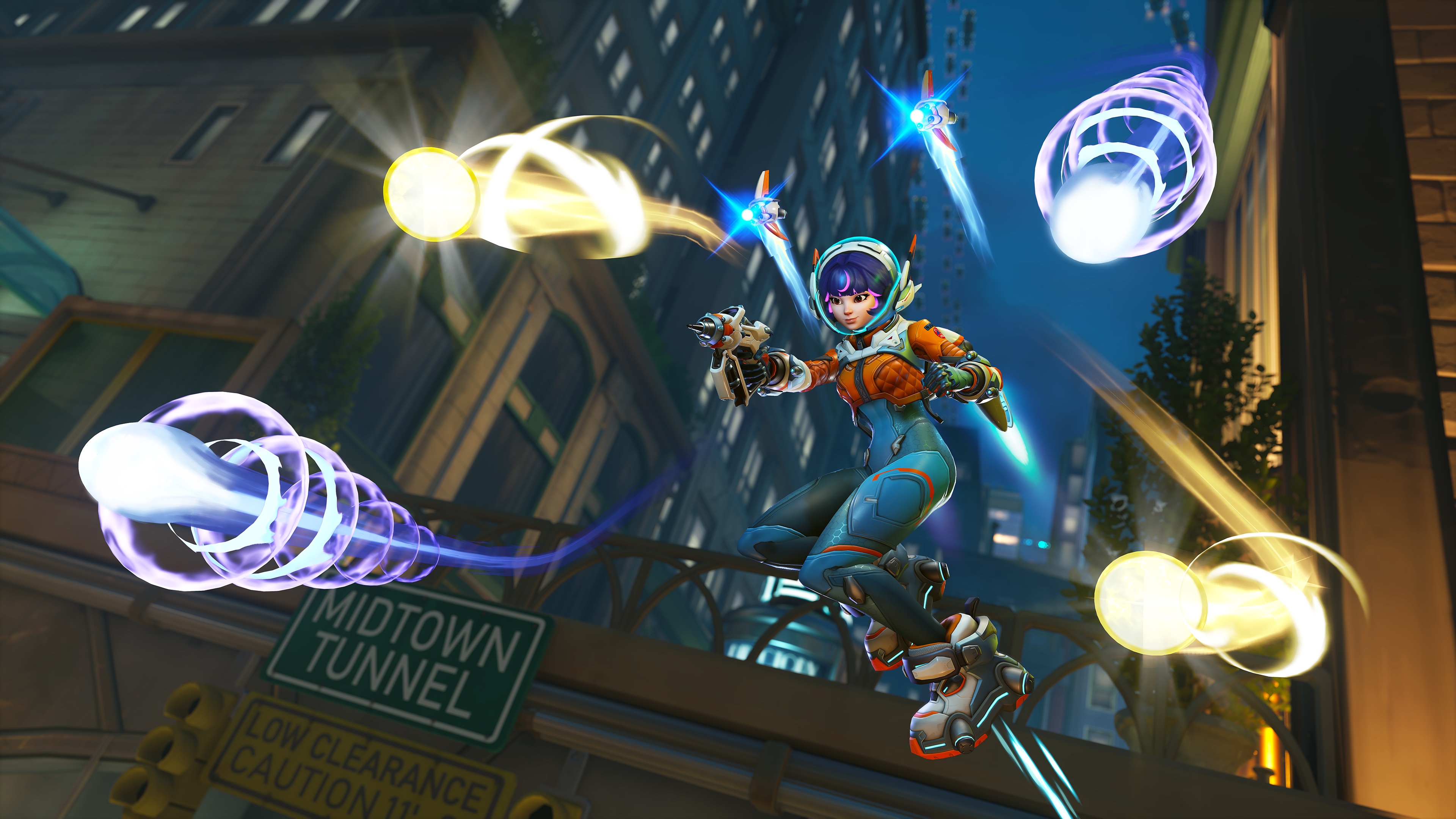 Juno fires her Pulsar Torpedoes while flying over the Midtown map in a screenshot from Overwatch 2