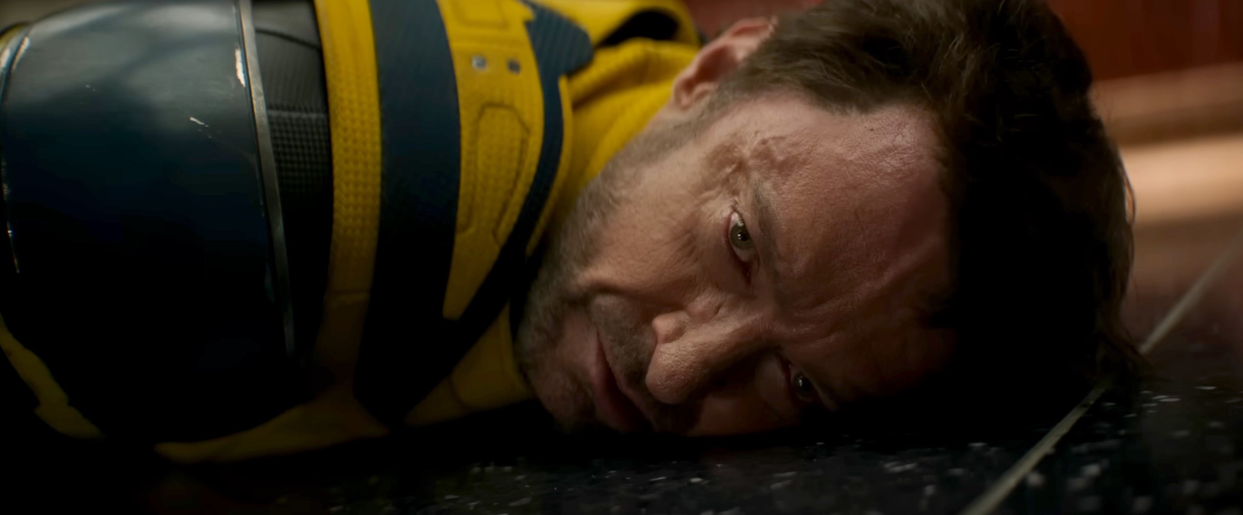 Wolverine (Hugh Jackman) flops on his stomach on the ground in Deadpool & Wolverine