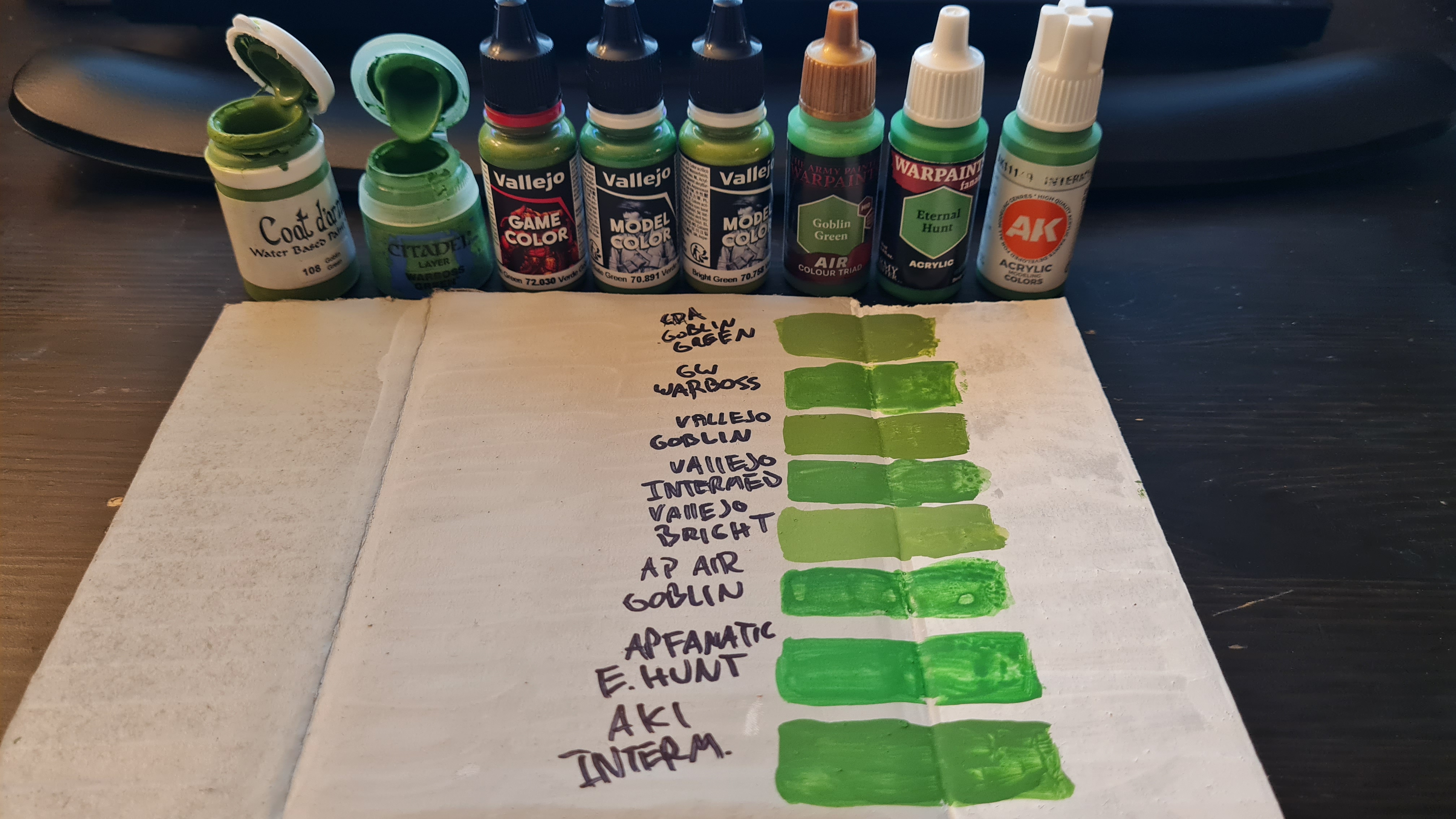 A rough swatch comparing several green miniature paints. Coat d'Arms Goblin Green paint is at the top, as an approximate control sample.