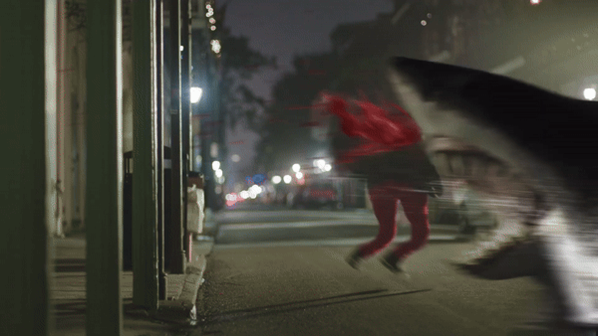 A gif of a badly realized CG shark skidding through the streets of New Orleans devouring people, with sprays of very bright red, very fake-looking blood