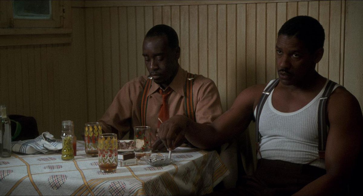 Denzel Washington and Don Cheadle sit next to each other at a full table in Devil in a Blue Dress