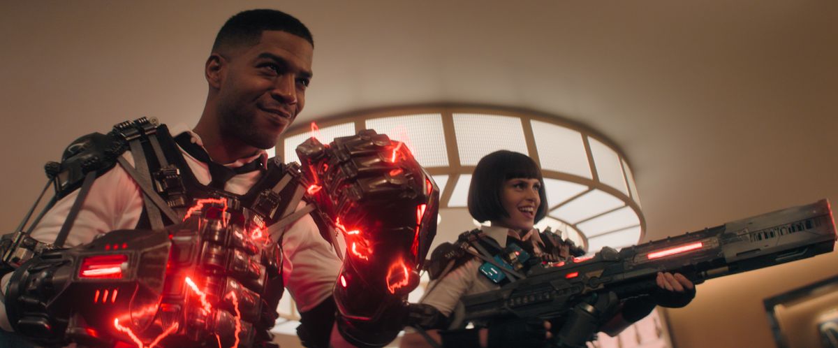 Scott Mescudi as Agent Mason and Ellie Taylor as Agent Willoughby in Knuckles standing with supercharged red energy gloves and a giant gun