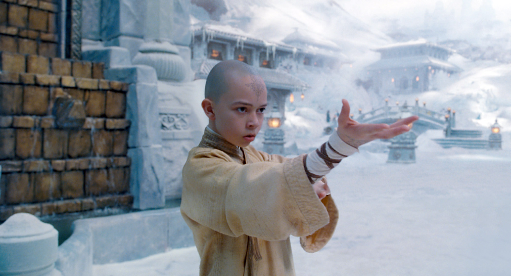 Noah Ringer as Aang in The Last Airbender standing in a snowy area outside of a castle 