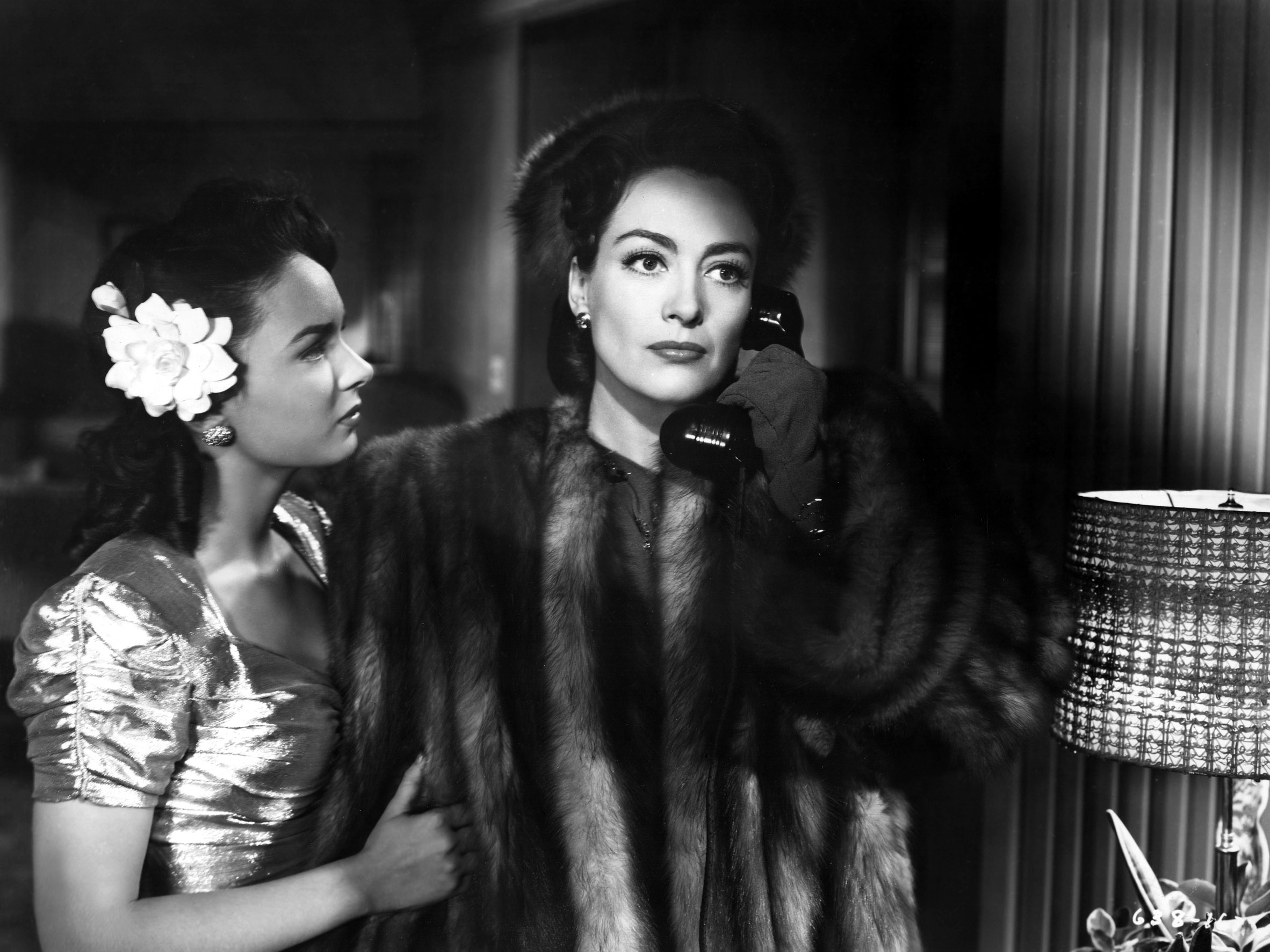 Joan Crawford, on the phone in Mildred Pierce, with Ann Blyth holding onto her fur coat