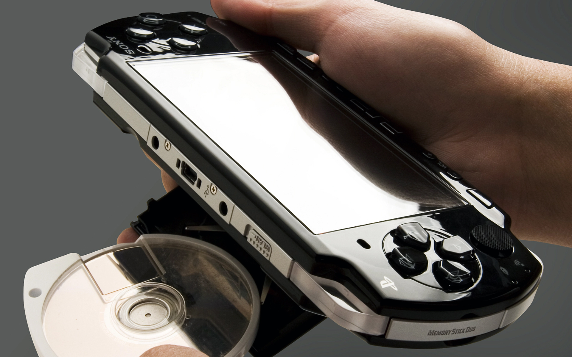 A product photo of the PSP with a UMD being inserted