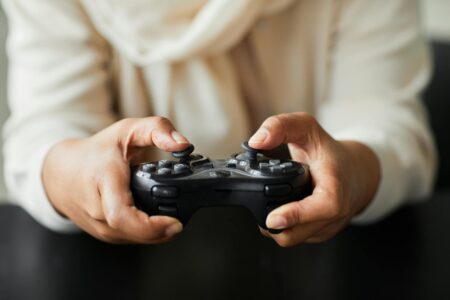 Hands holding a modern gaming controller for mobile gaming