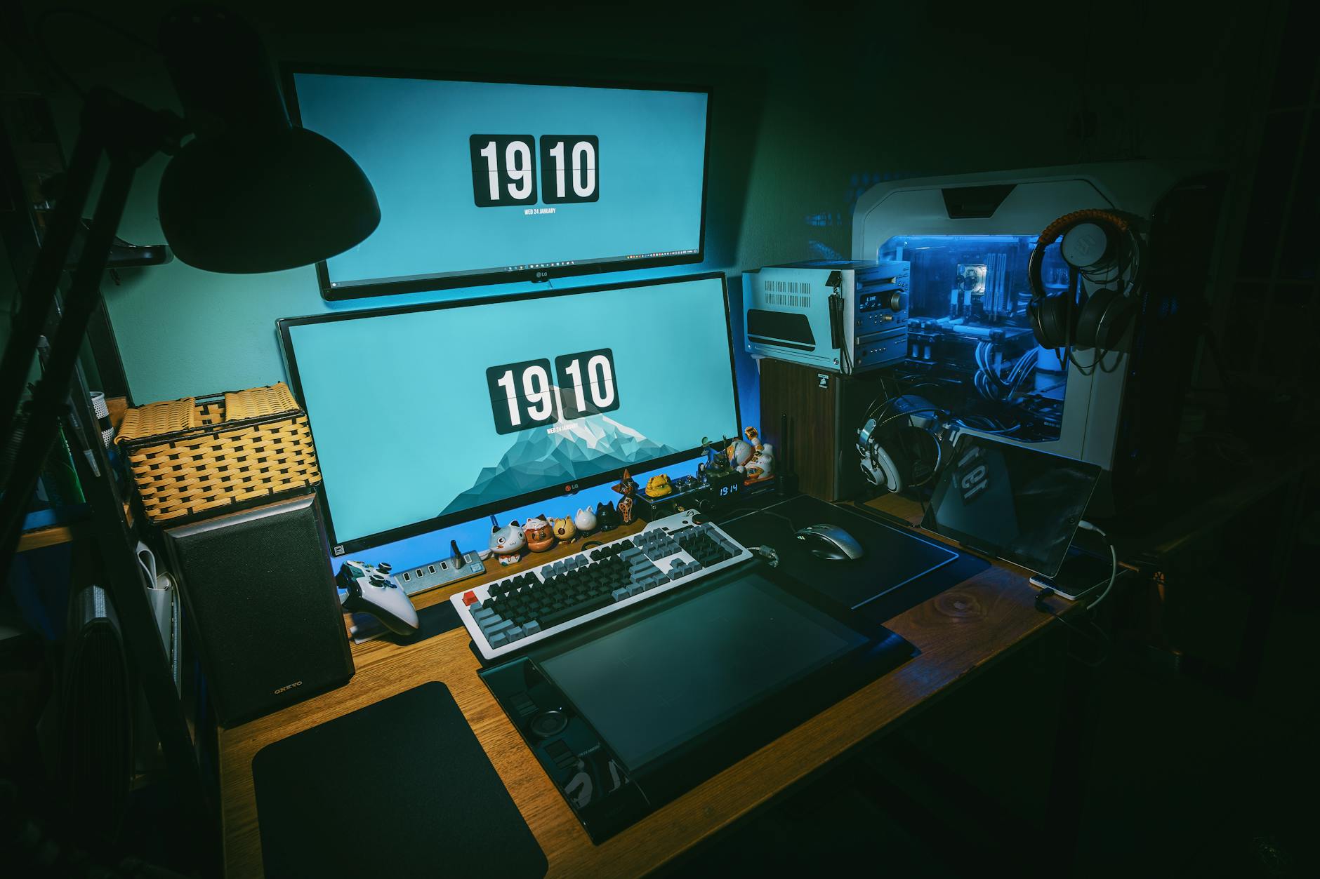 Modern gaming desk setup with multiple monitors and LED lighting in a streaming configuration