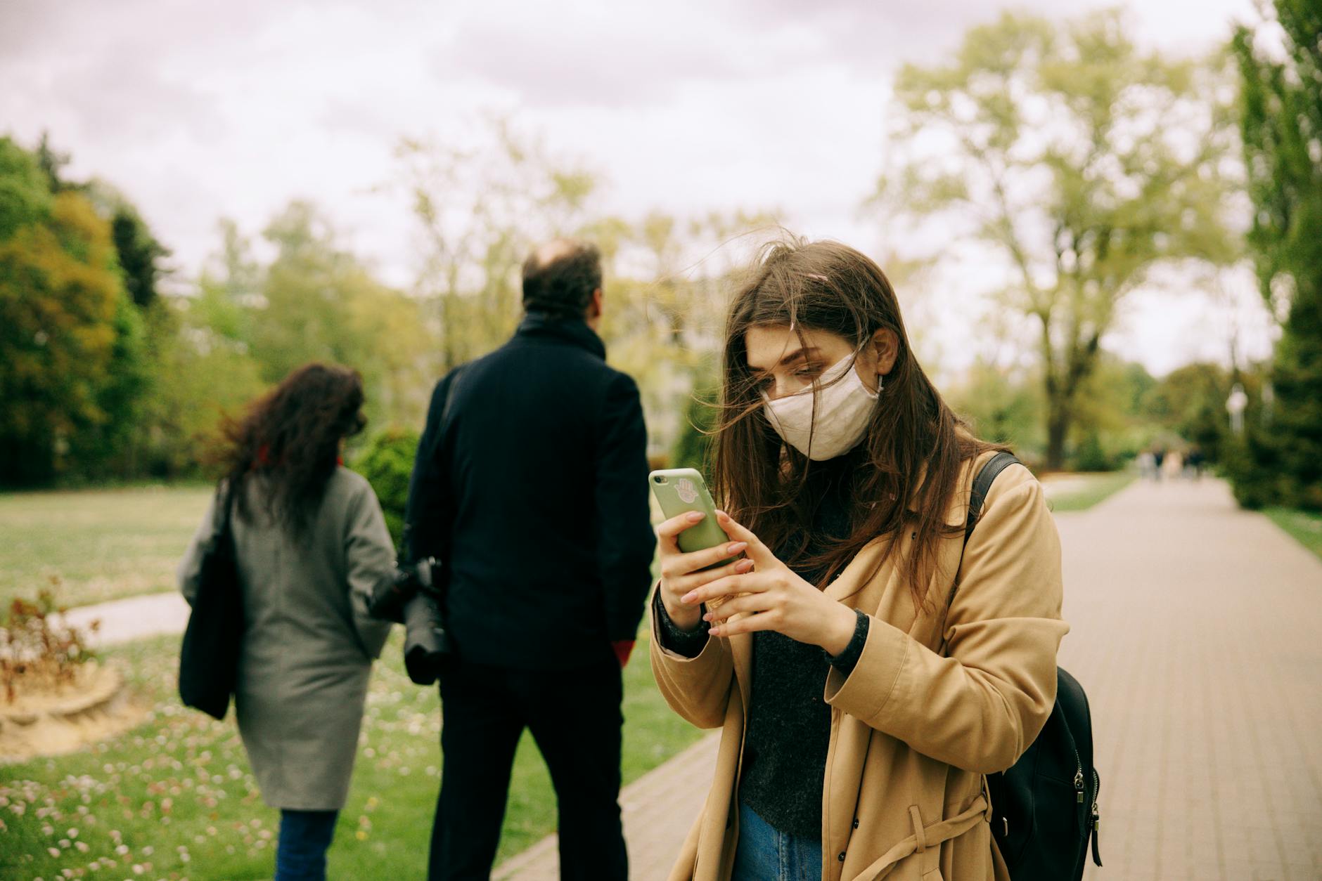 Group of people walking outdoors while looking at their mobile phones, representing mobile gaming community engagement