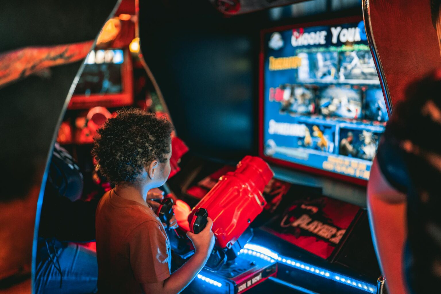 Vintage arcade game cabinets lined up in a retro gaming cafe with colorful screens and classic joystick controls