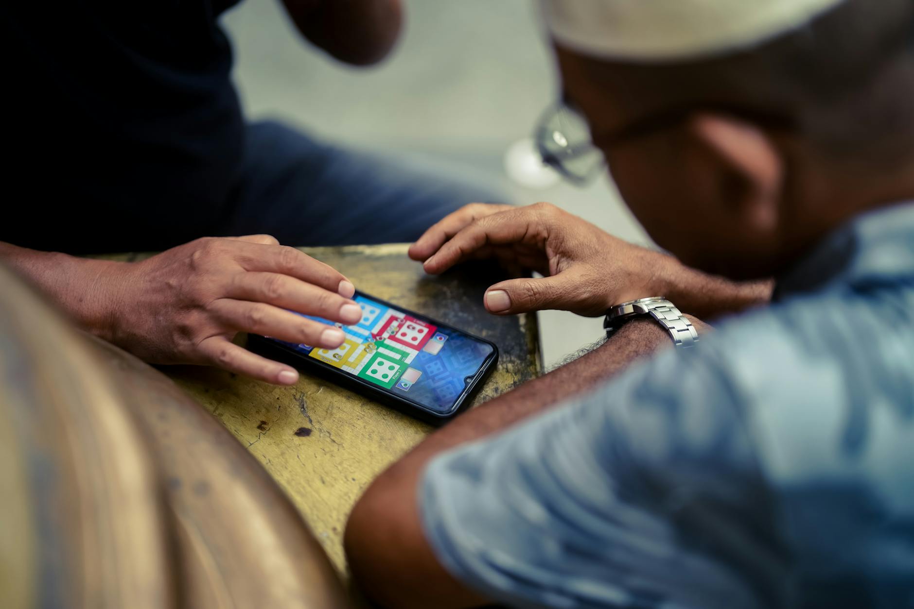 Close-up of hands holding smartphone while playing mobile racing game