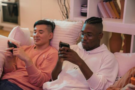 Person holding smartphone playing mobile game with colorful screen display