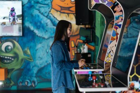 Row of classic arcade gaming cabinets with colorful screens in dimly lit gaming venue