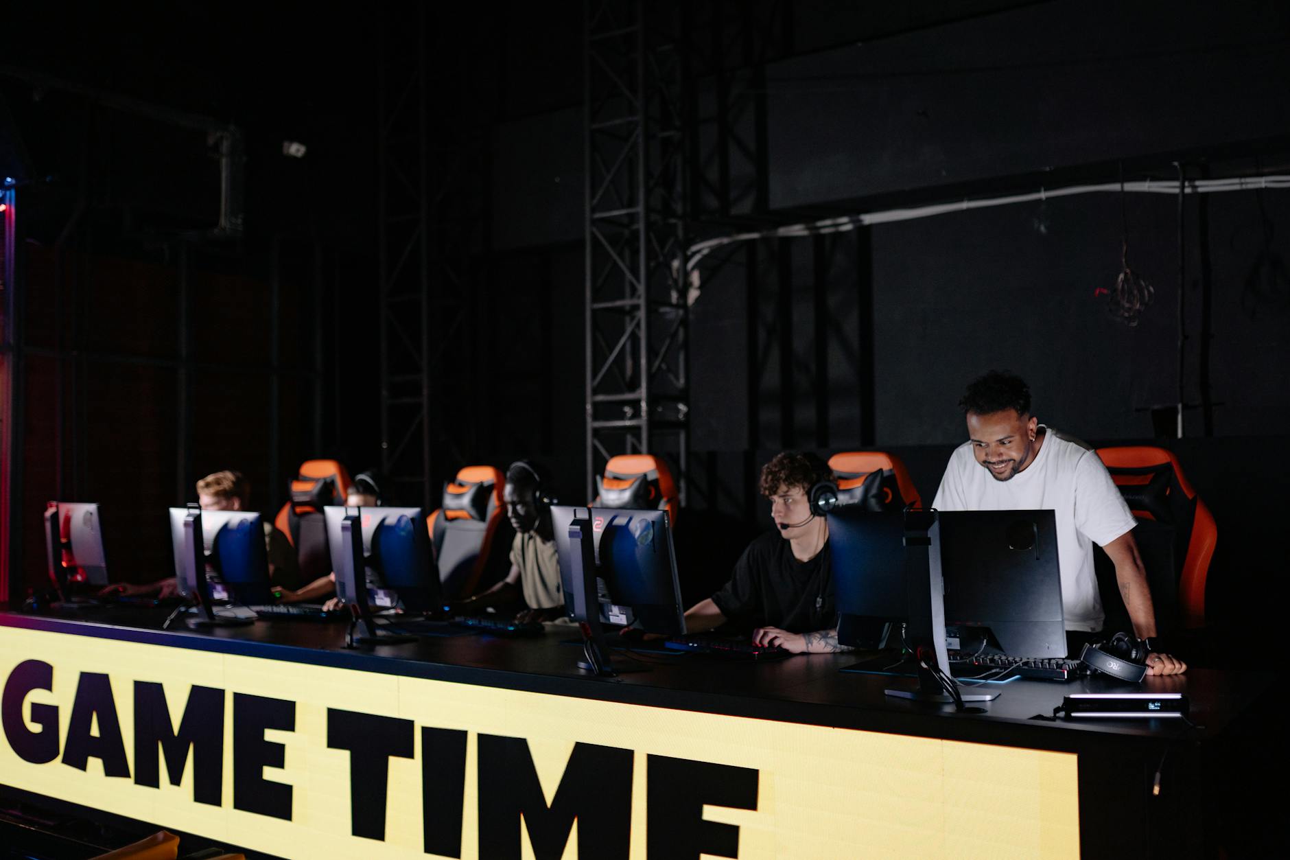 Professional gaming tournament setup with competitors at stations under bright lights