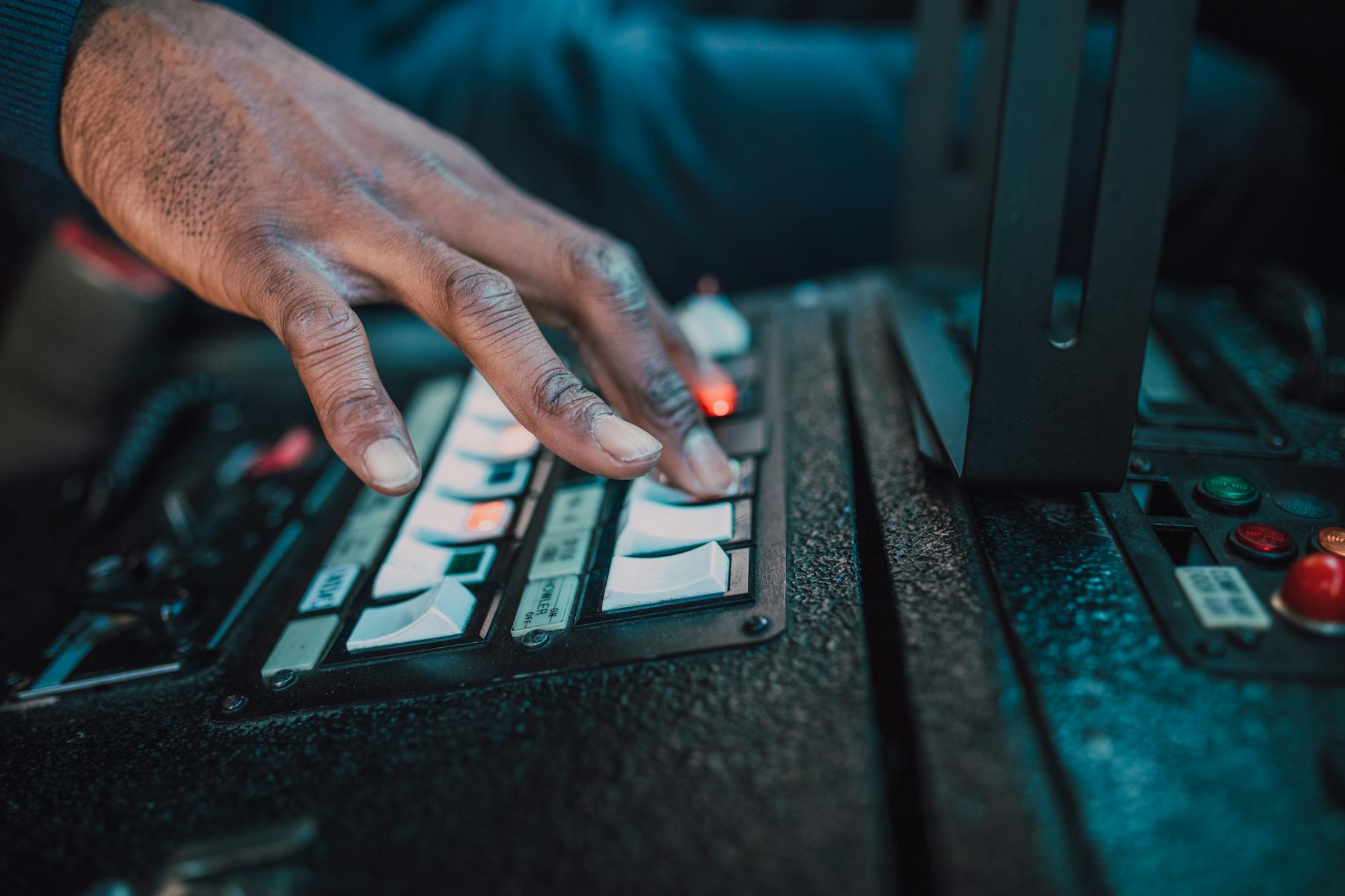Hands holding gaming controller with colorful lighting in background