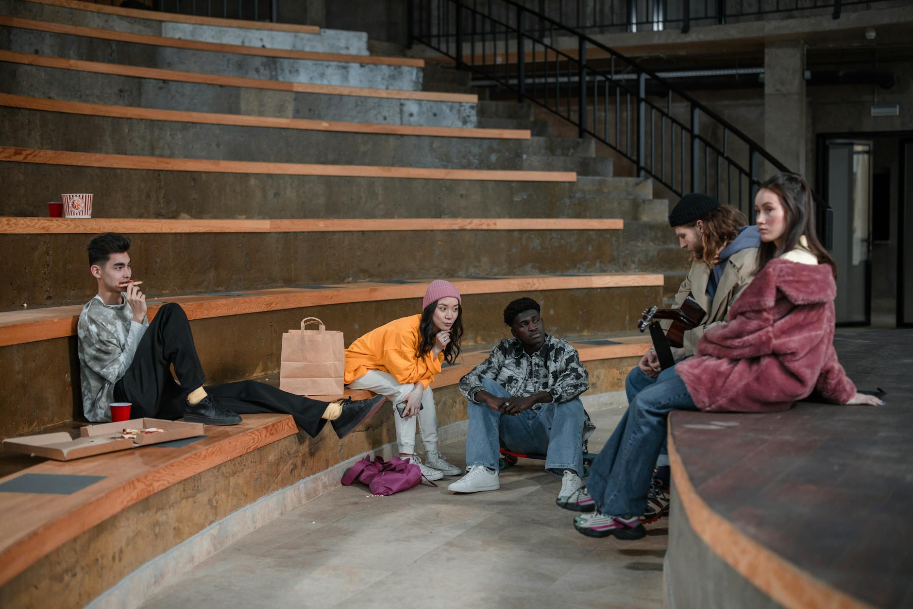 Group of young adults gathered around gaming setup, laughing and holding controllers
