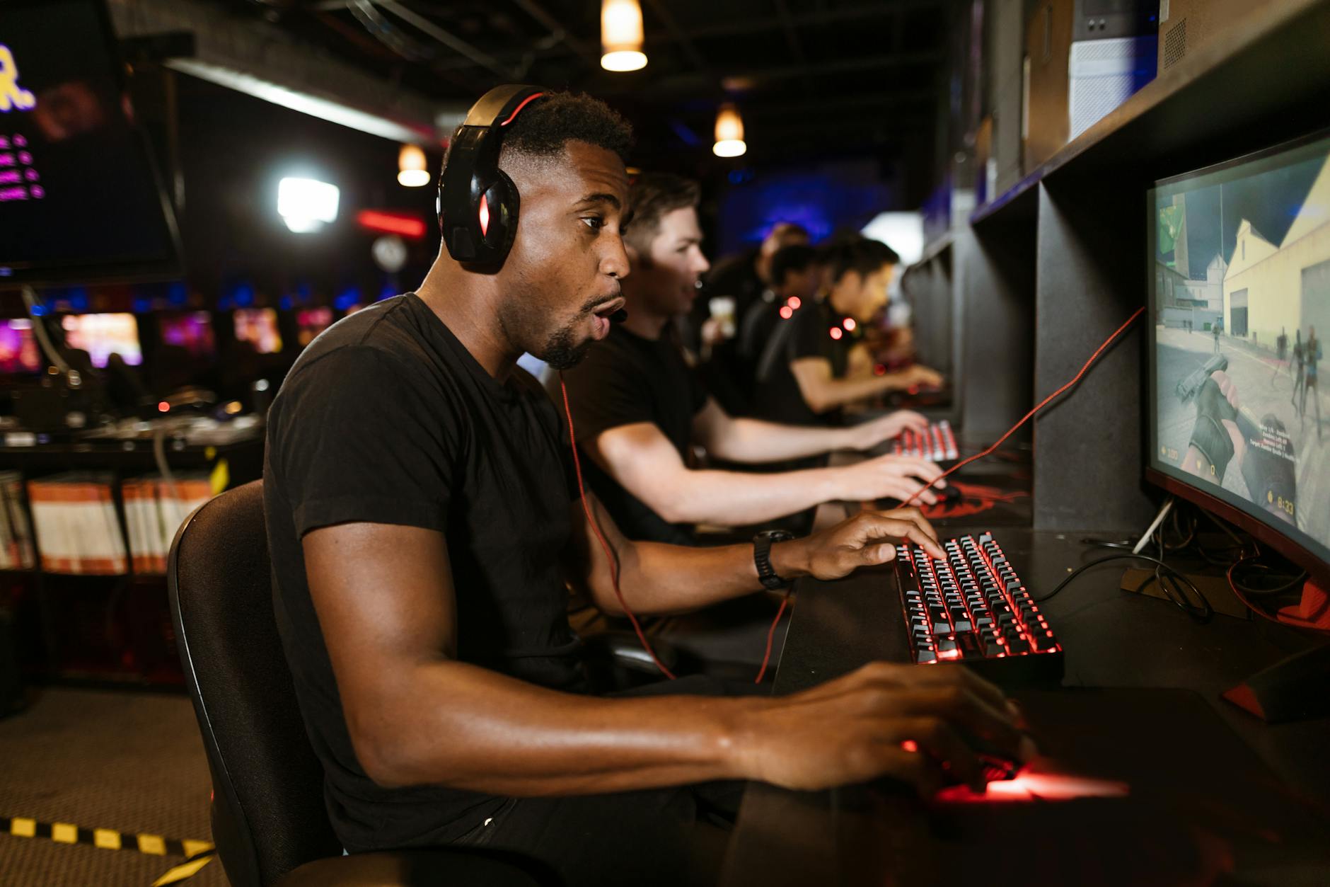 Professional esports players competing at gaming tournament with high-end gaming setups