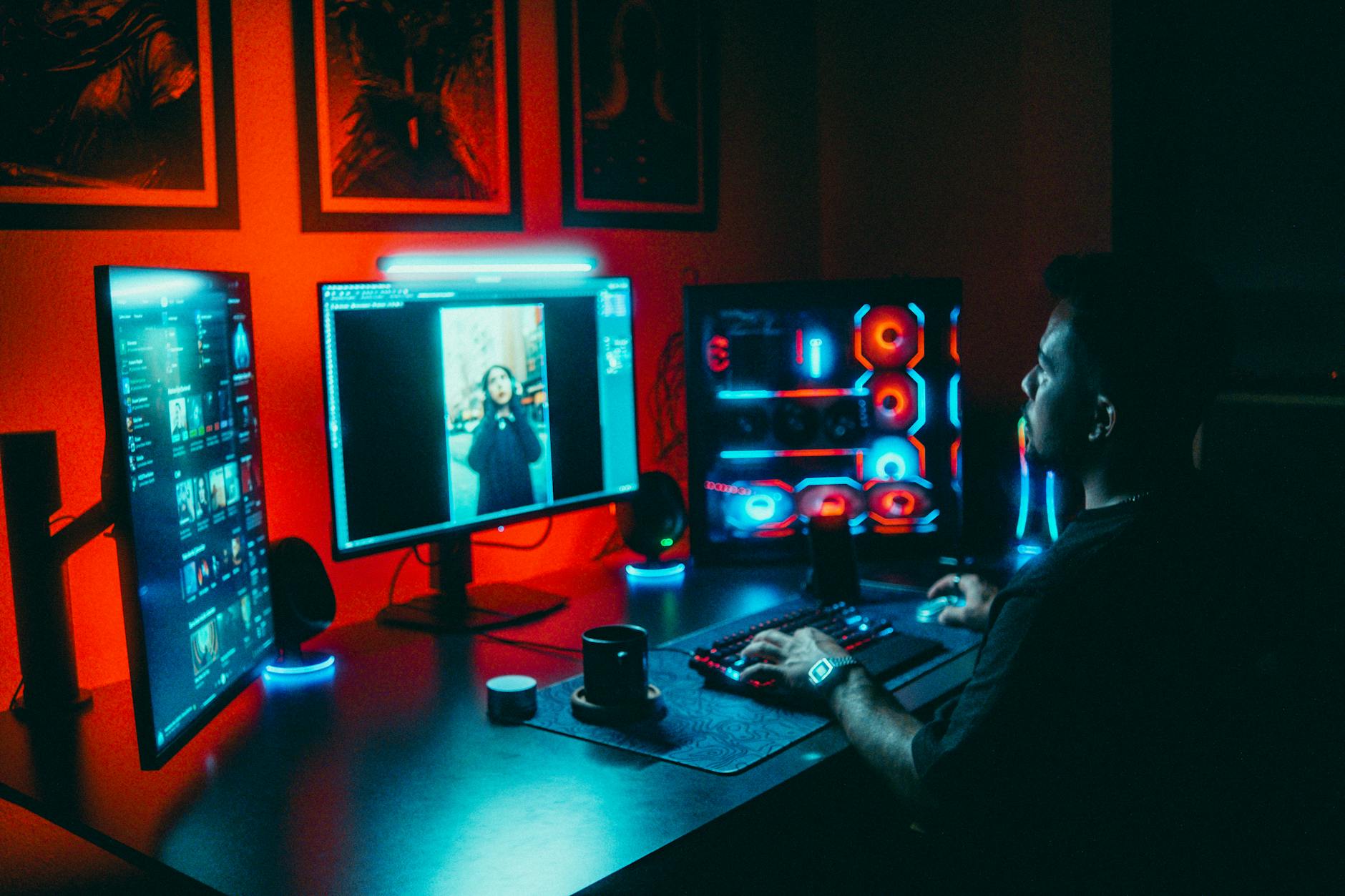 Video game development workspace with monitors displaying game design software