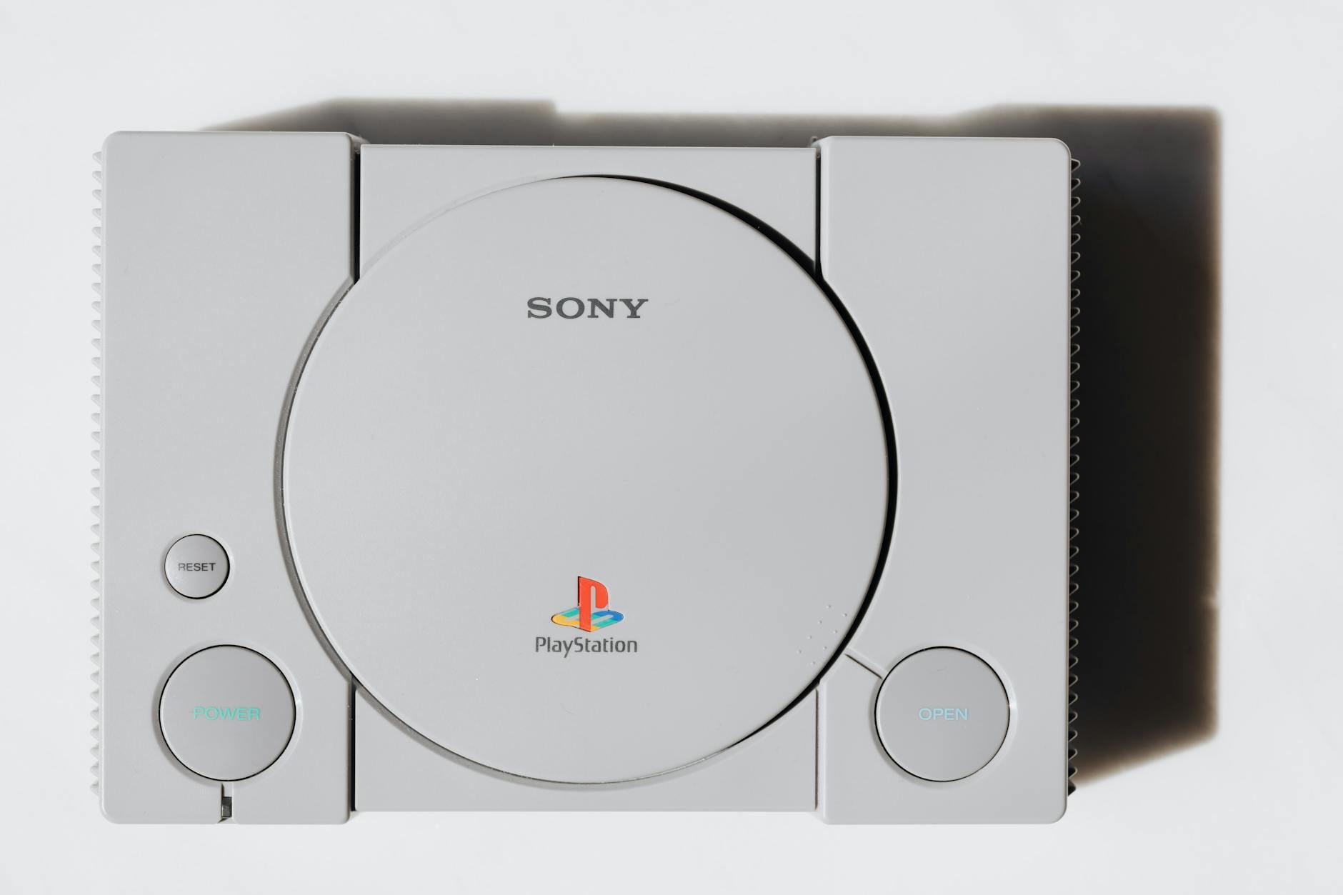 A PlayStation gaming console and controller set up on a entertainment unit in a living room