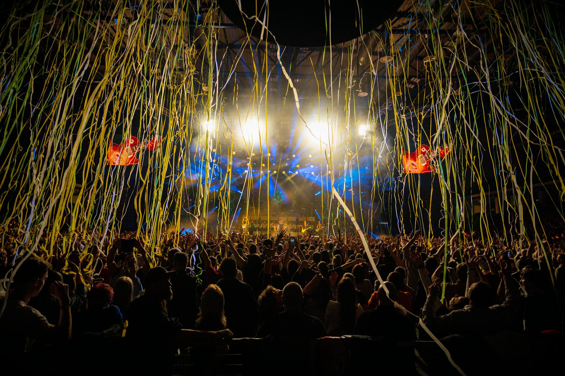 Large crowd at music venue with stage lighting