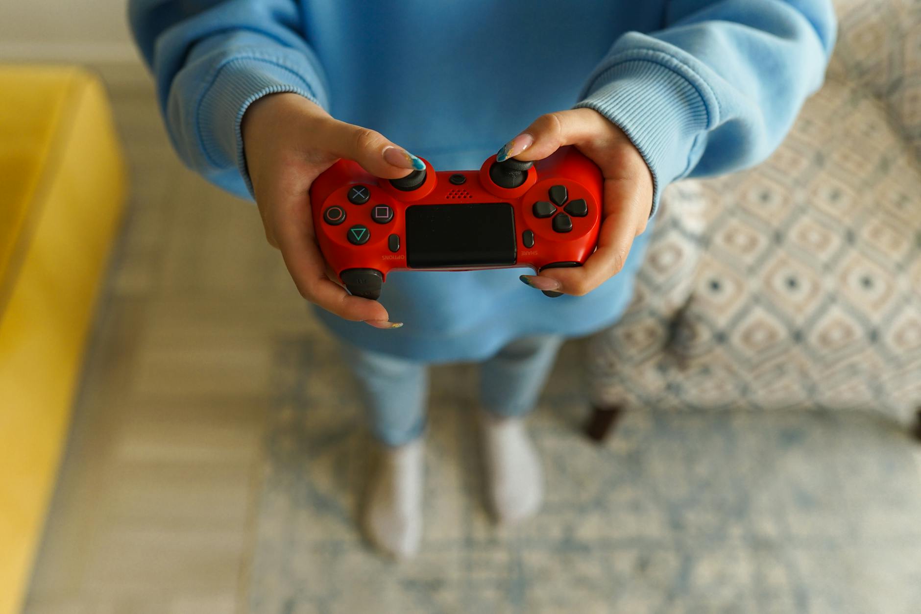 PlayStation and PC gaming controllers side by side on wooden desk surface
