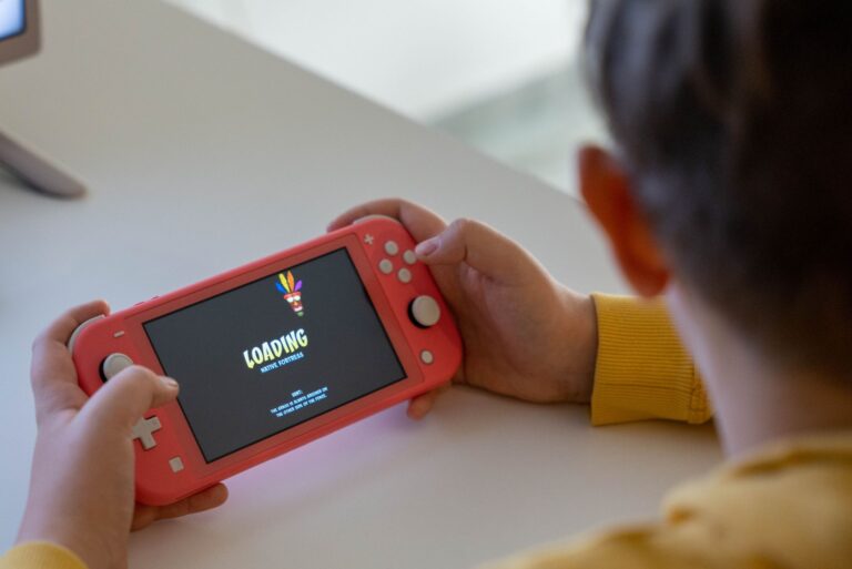 Person playing a handheld gaming console on a couch