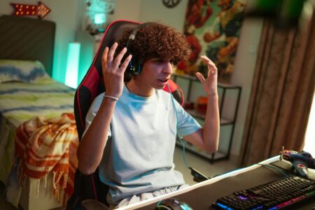 Gaming headset resting on a desk next to a portable game console