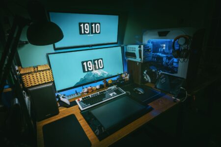 A video game developer's workspace with monitors and design materials