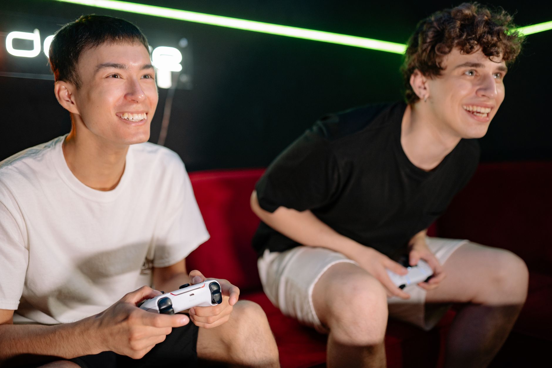 Group of friends gathered around screens playing video games together