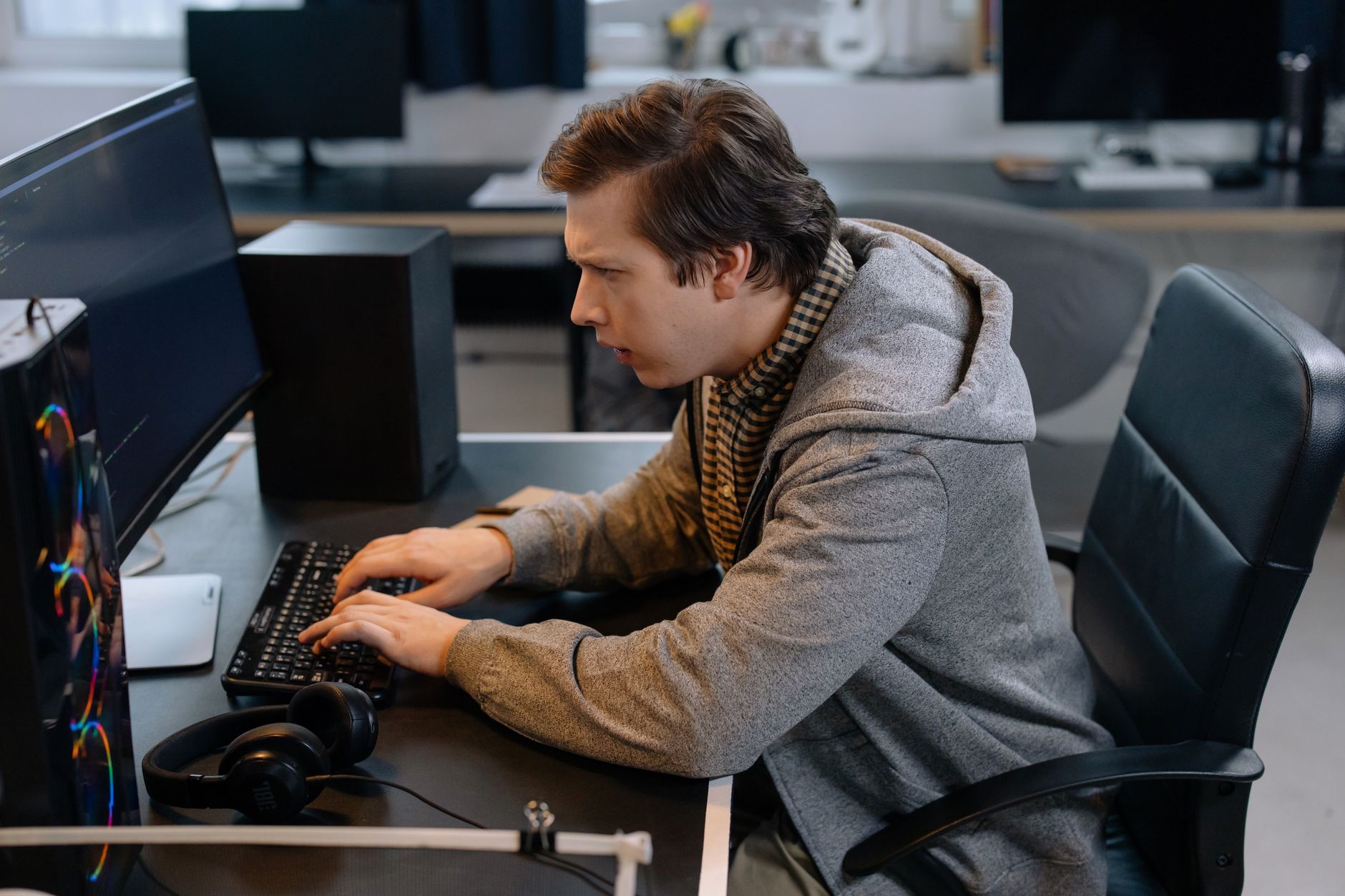 A small team developer working at a computer in a home studio environment