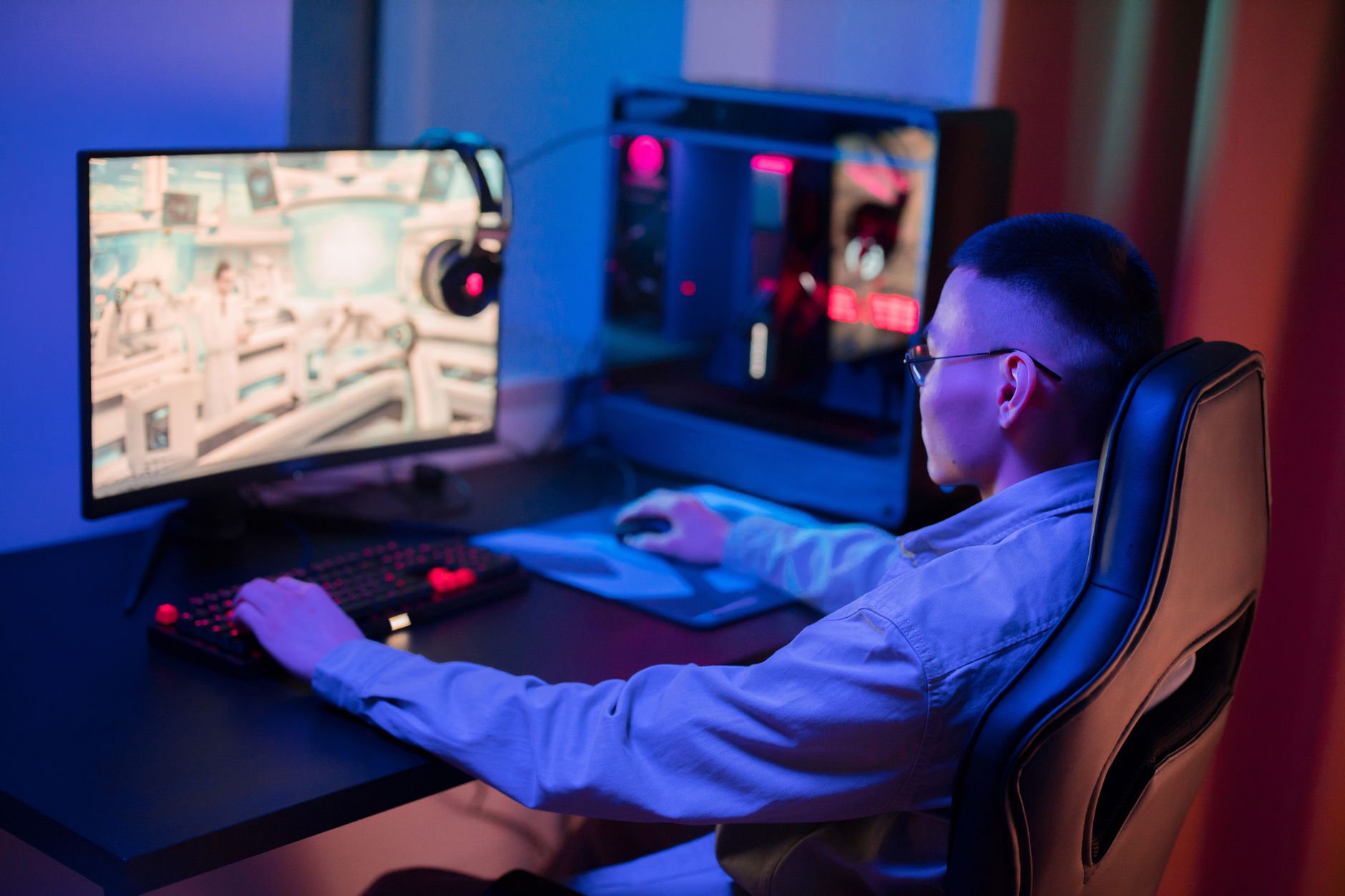 A content creator recording at a gaming desk with multiple monitors