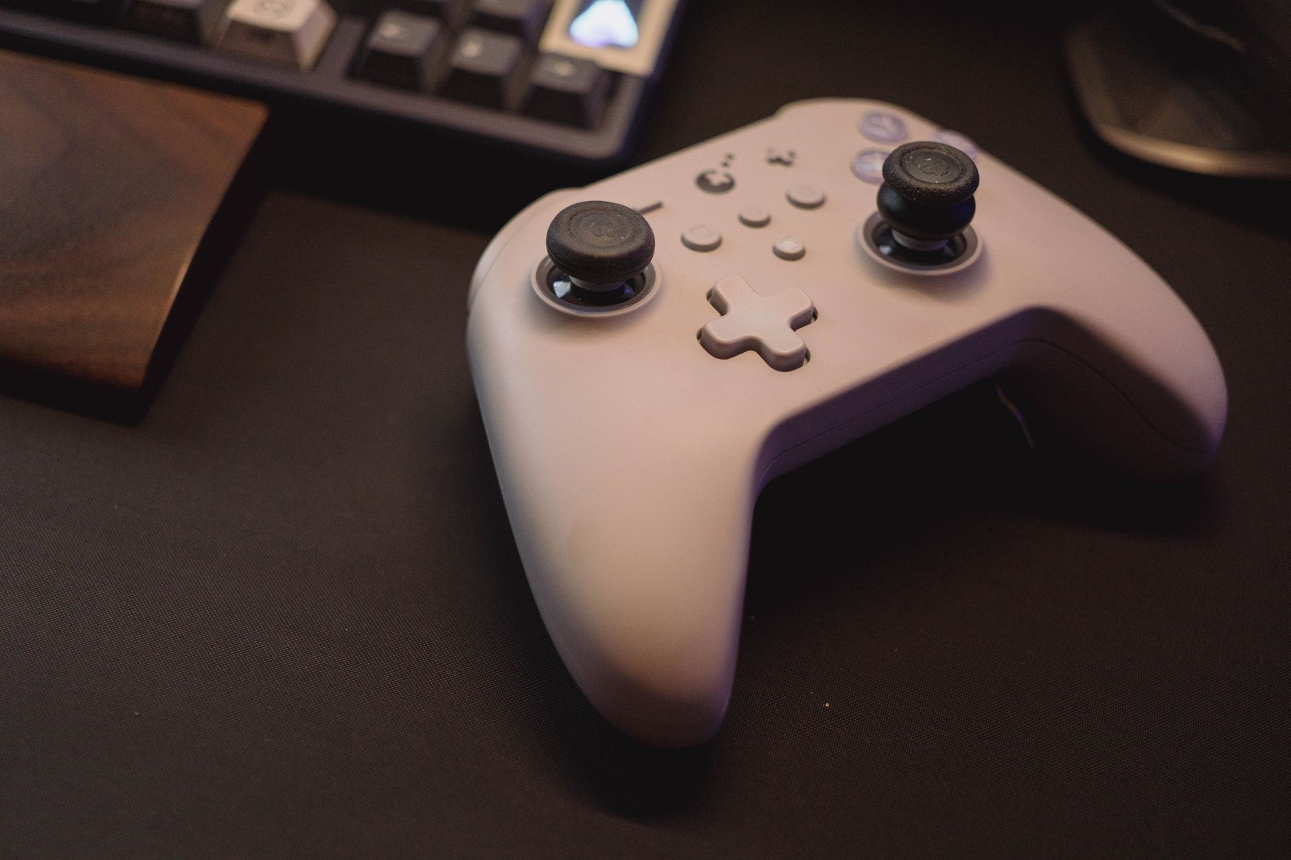 A game controller resting on a desk beside a computer monitor