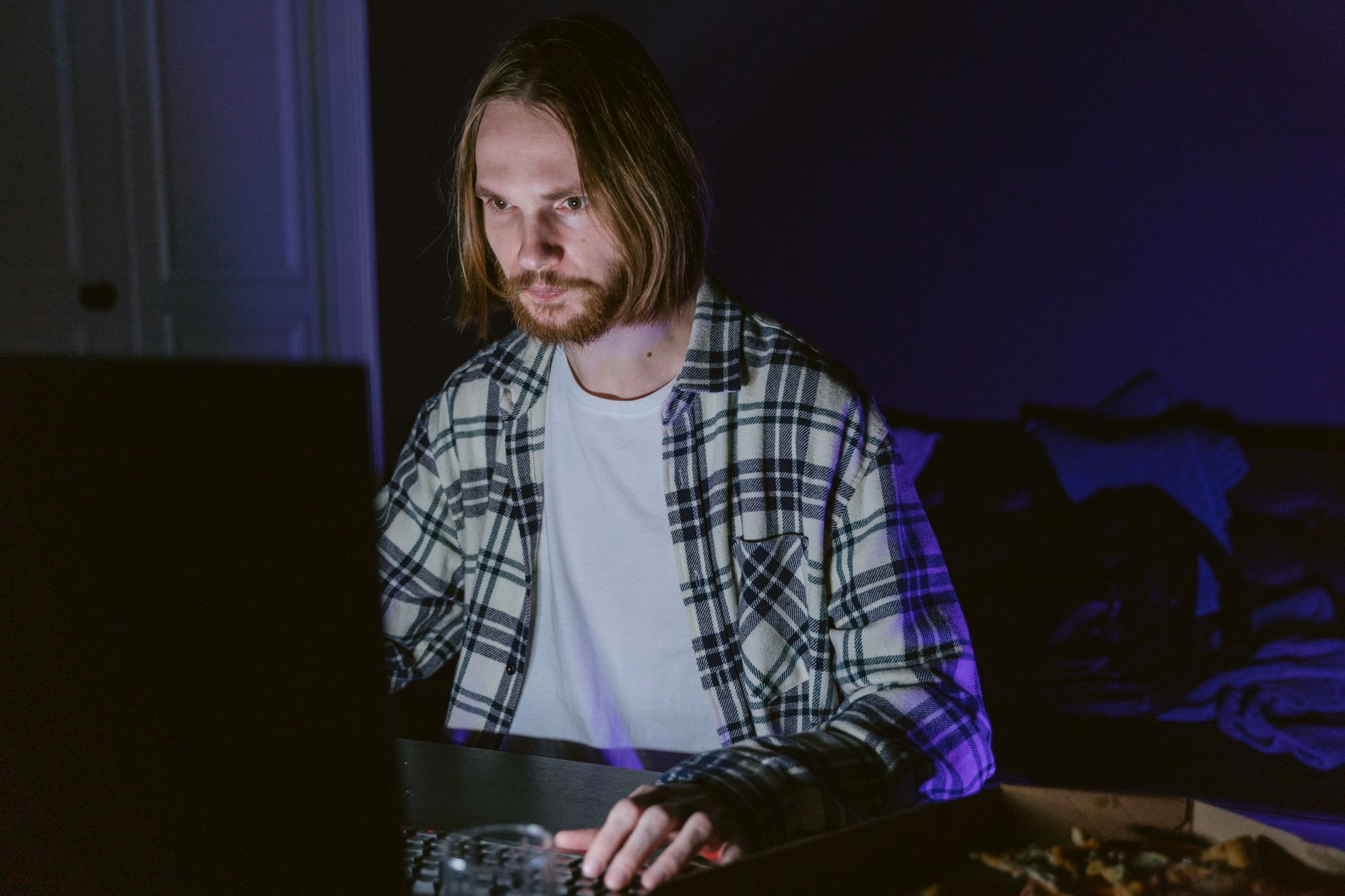 A person playing a video game alone in a dimly lit room at night