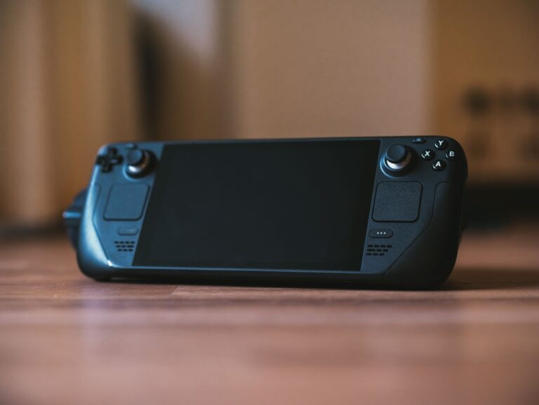 Person playing a handheld gaming console with a colorful game on screen