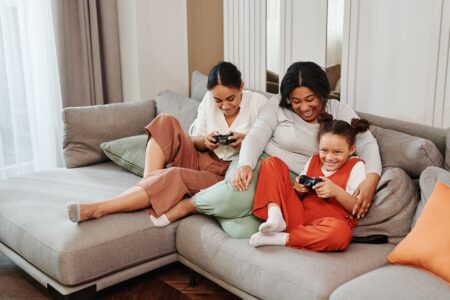A family sitting together in a living room using a gaming console