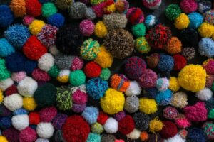 Yoshi’s Woolly World Sequel Silence Is Straining Franchise Momentum Colorful balls of yarn arranged together, representing the handcrafted aesthetic of Yoshi's Woolly World