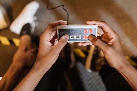 Pikmin 4’s Multiplayer Absence Is Quietly Limiting Its Mainstream Ceiling A game controller resting near a TV screen showing a colorful strategy game environment