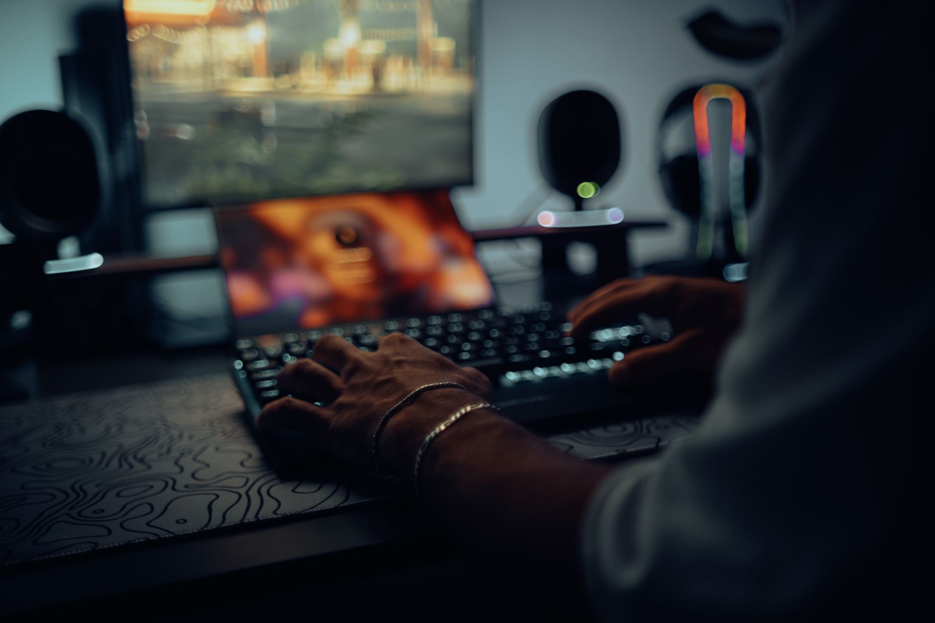 Game developer working at a desk with multiple monitors showing game design software