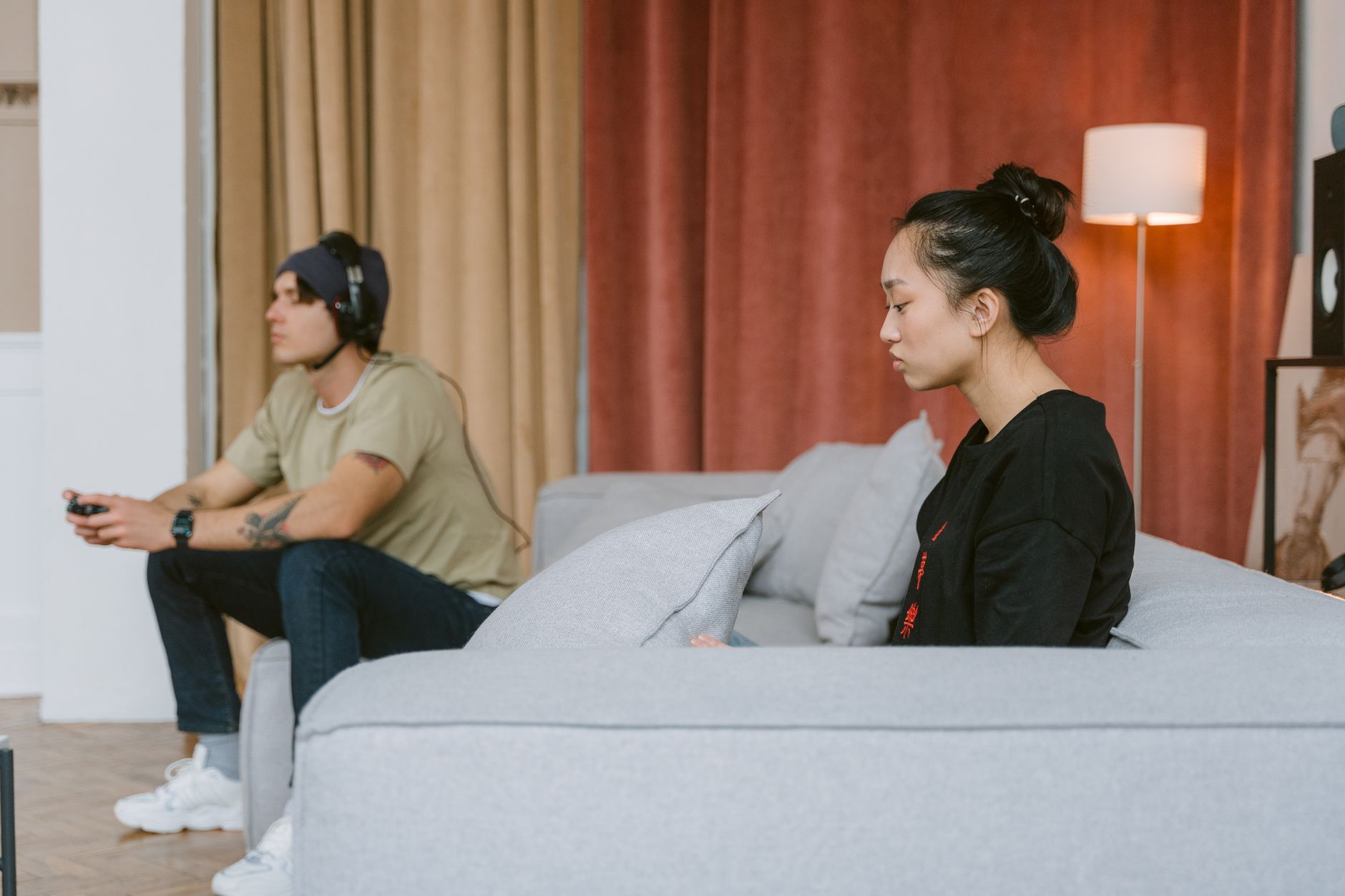 A person sitting on a couch playing a video game, reflecting the experience of revisiting older titles while waiting for new content