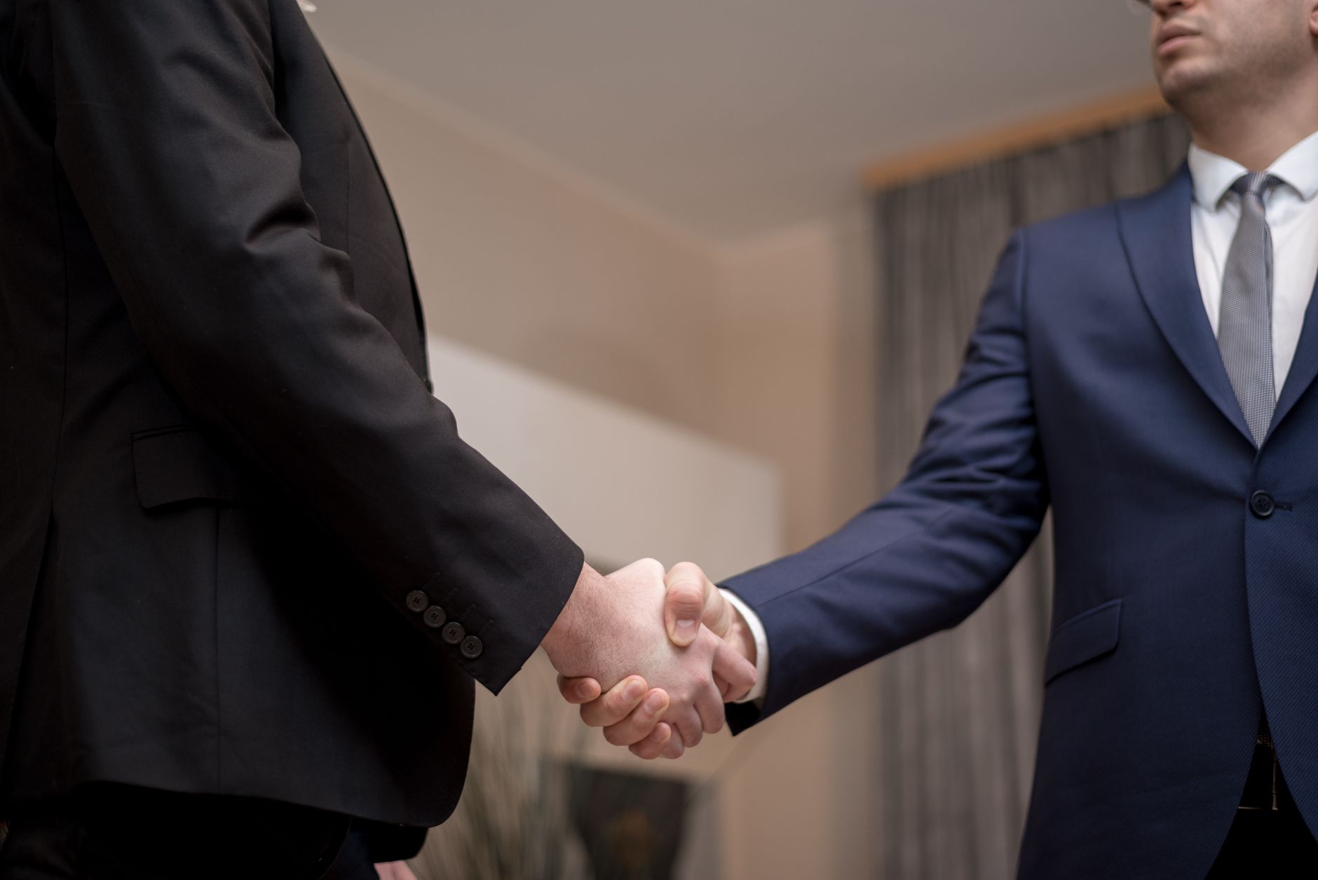 Two people shaking hands representing a corporate licensing deal, symbolizing the negotiations required between Nintendo and Microsoft