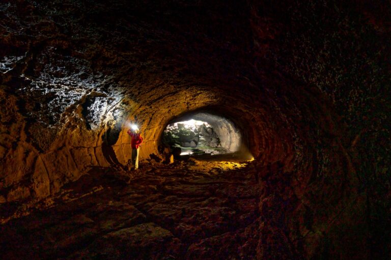 A dark underground cave tunnel representing the layered world structure in Donkey Kong Bananza