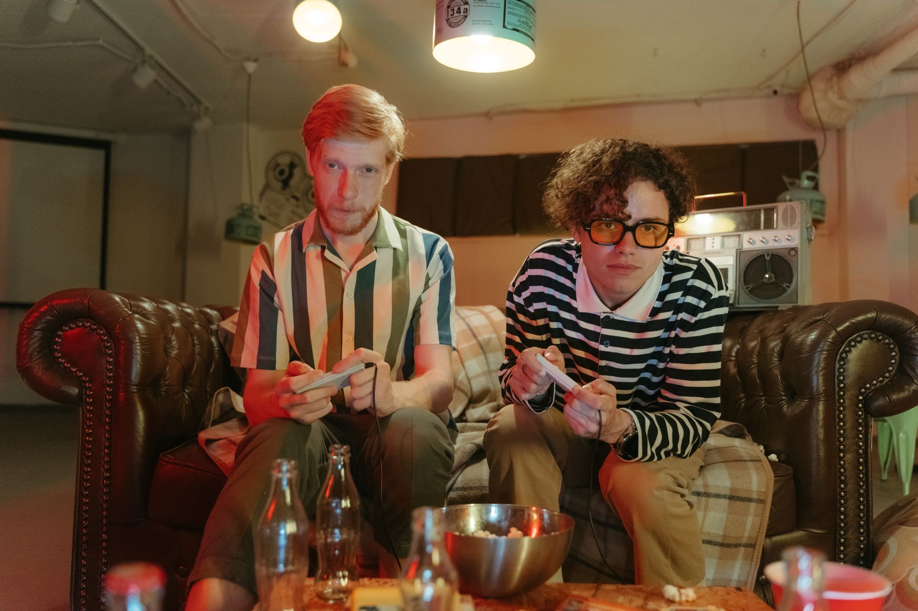 Two friends playing video games together on a couch, representing multiplayer gaming nostalgia