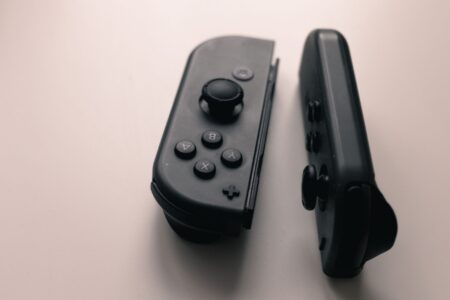 Donkey Kong Bananza’s Dixie Kong Absence Is Quietly Frustrating Co-Op Fans Two game controllers resting side by side, representing co-op multiplayer gaming