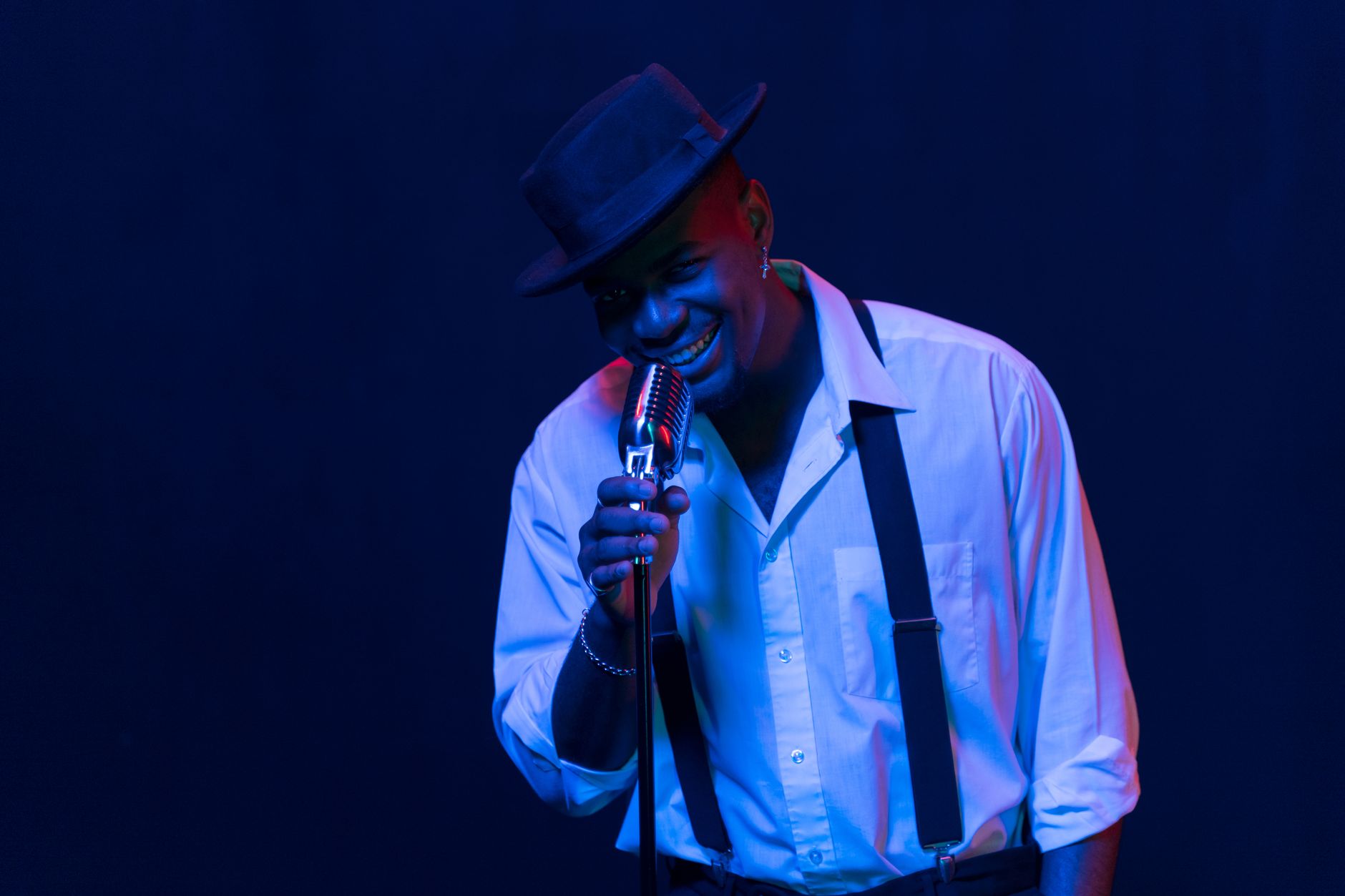 Female singer performing on a lit stage with a jazz band in the background