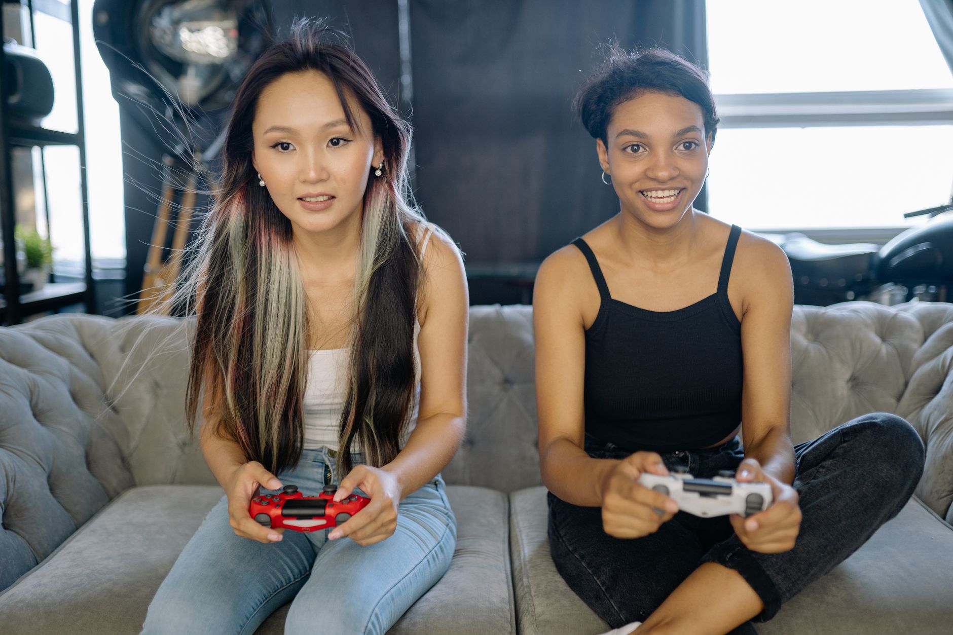 Two friends sitting together playing video games on a couch, representing co-op gaming culture