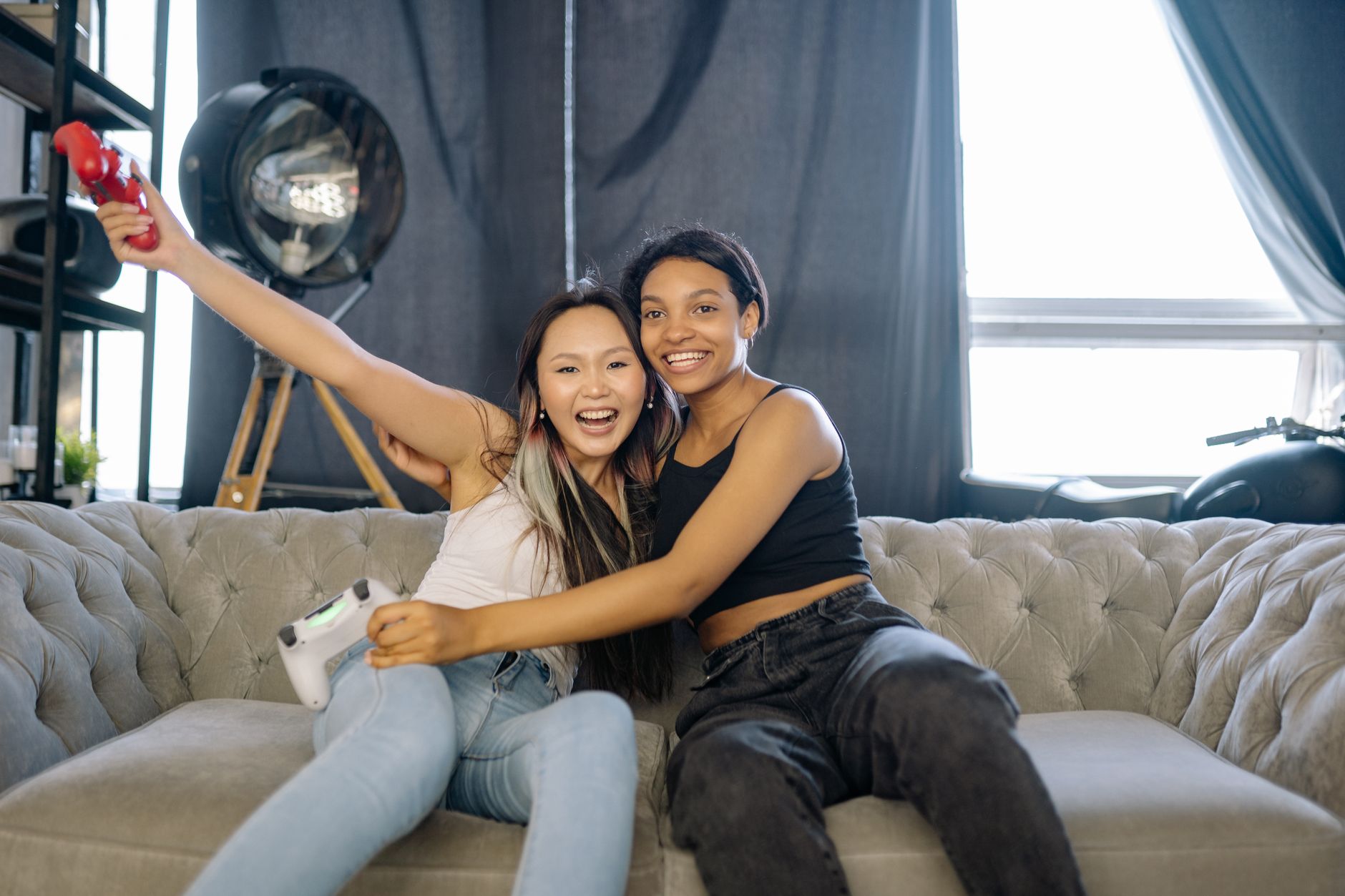 Two people sitting together playing a video game on a couch