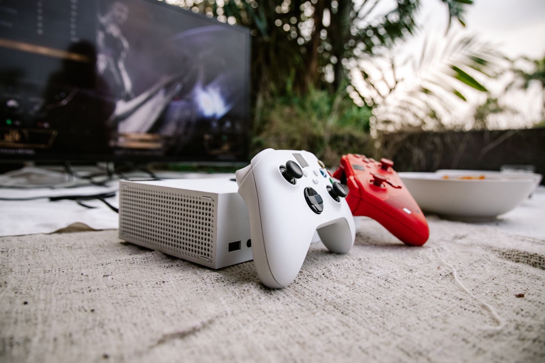Modern gaming console and controller arranged on a desk with soft ambient lighting